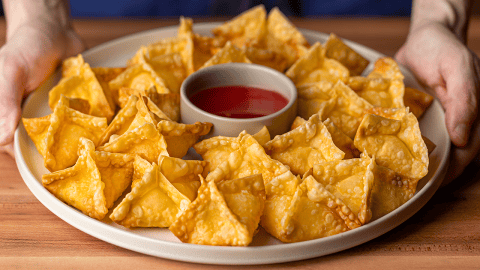 crab rangoons with sweet and sour dipping sauce on plate