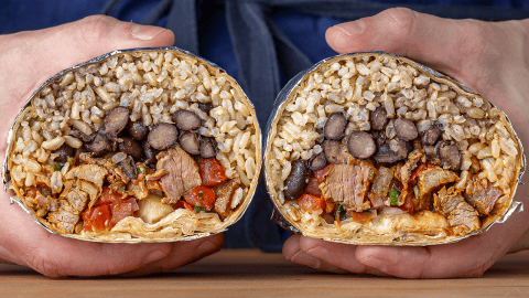 Chipotle steak burrito cut in half showing steak, rice, beans, and salsa