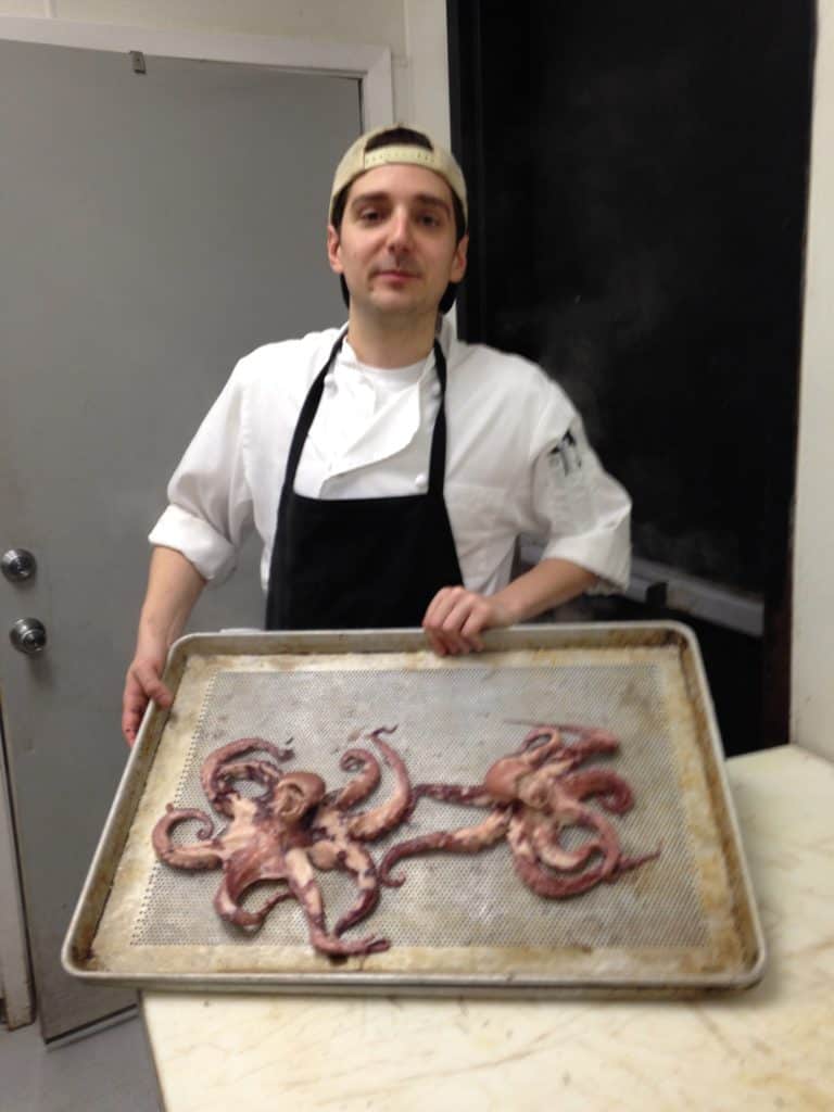Jason Farmer holding a tray of boiled octopus