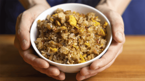 Benihana fried rice with sesame seeds and sliced green onion in a white bowl