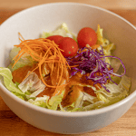 Benihana ginger salad dressing served over iceberg lettuce with cabbage carrots and tomato