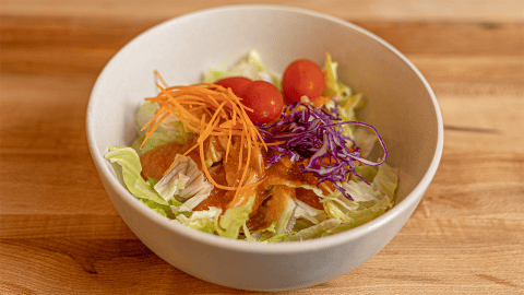Benihana ginger salad dressing served over iceberg lettuce with cabbage carrots and tomato