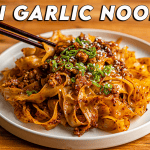 Chili garlic noodles with ground pork, sesame seeds, and green onions