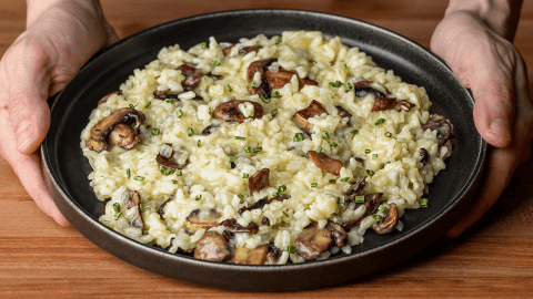 Gordon Ramsay mushroom risotto plated with sauteed mushrooms and chives