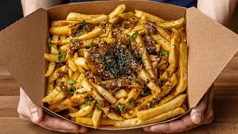Japanese curry fries topped with bonito flakes sesame seeds scallions and kizami nori