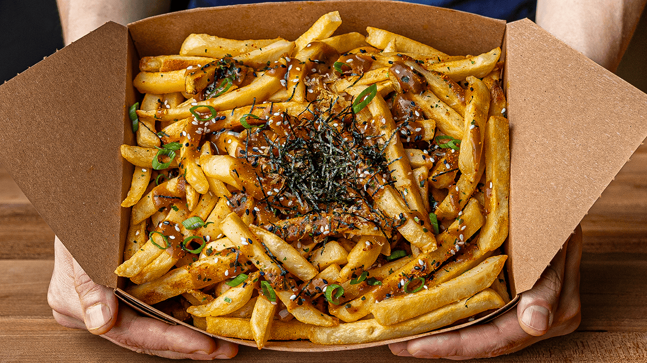 Japanese curry fries topped with bonito flakes sesame seeds scallions and kizami nori