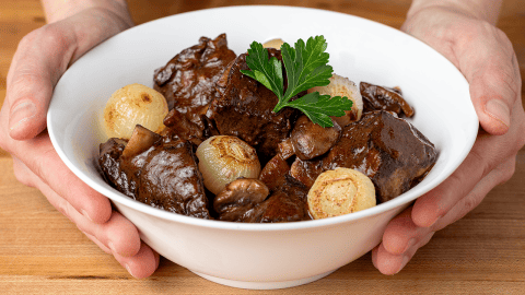 Julia Child beef bourguignon with pearl onions and mushrooms in a Dutch oven