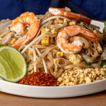pad thai with shrimp garnished with lime peanuts and bean sprouts