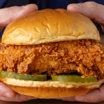 Popeyes fried chicken sandwich on a toasted brioche bun with pickles and mayo