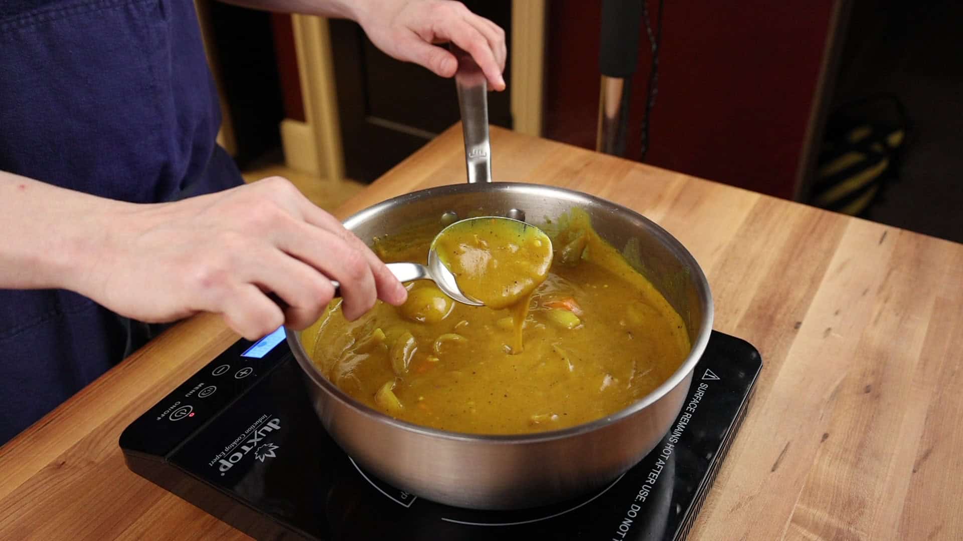 Ladle lifting thick Japanese curry out of the pot
